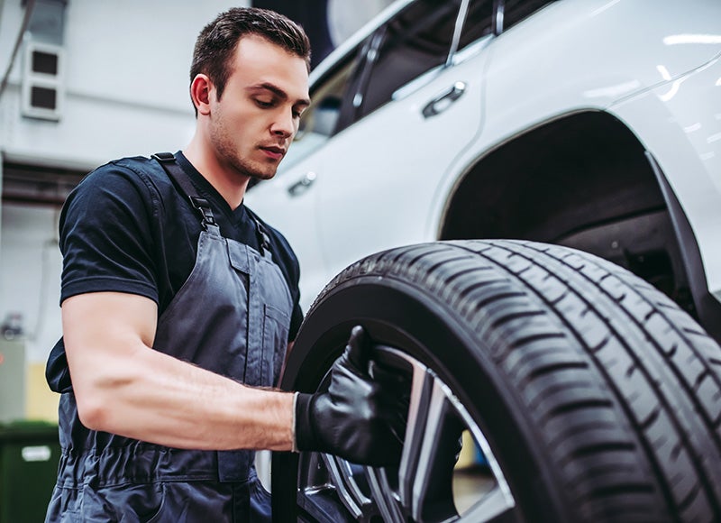 Technician inspecting a tire for service